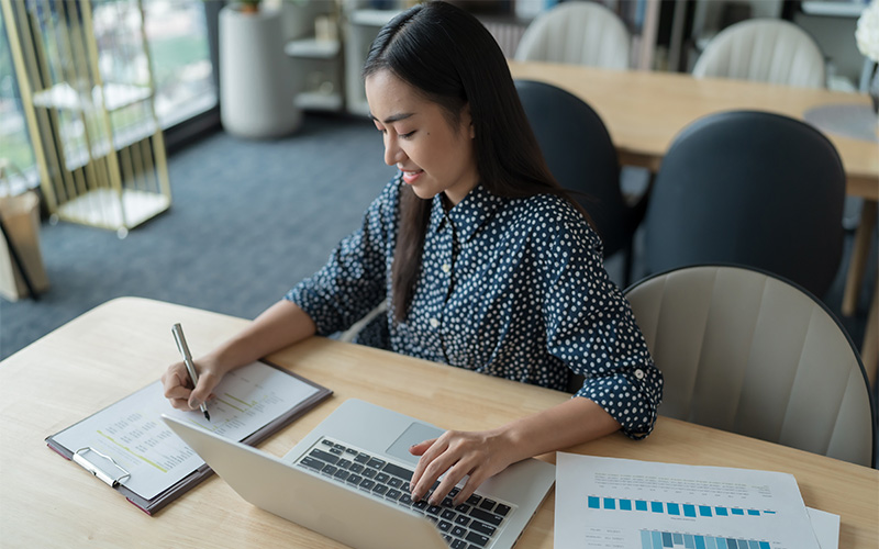 Professional working on financial data using a laptop.