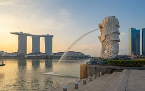 Merlion statue spitting water with Marina Bay Sands background.