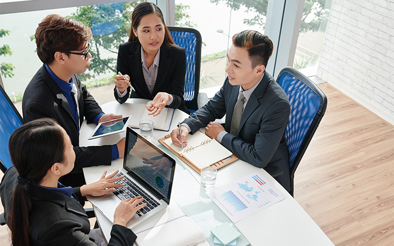 Corporate team analyzing business charts in a meeting room.