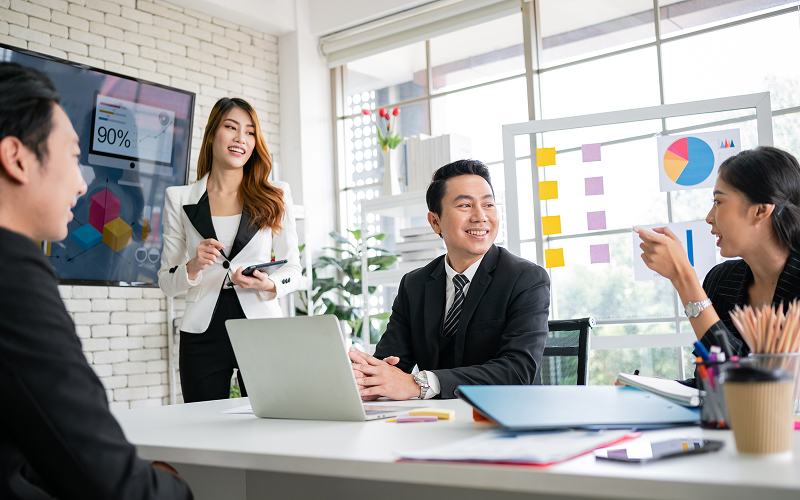 Singapore business team discussing financial updates in a modern office.